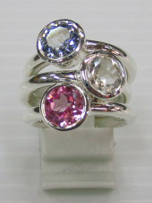 sterling silver Blue topaz , white topaz and pink topaz rings worn together.